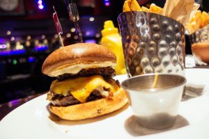 cheeseburger with fries on a while plate.