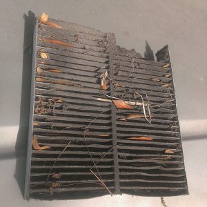 Cabin air filter that is dirty with leaves and dust.