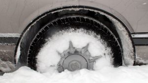 Cadillac car wheel stuck in the snow.